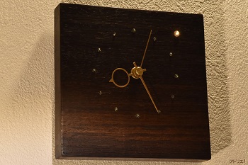 役員室のテーブルや一流バーカウンターなどに使用されるウエンジの辺材部分に現れた朝焼けにような希少な木目を生かし、スワロフスキーで明けの明星を配した時計です。