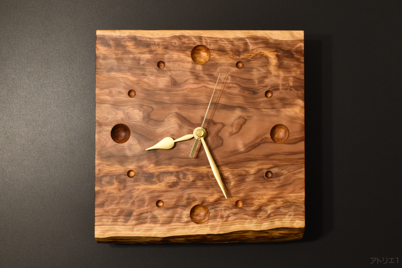 渦流のような杢をそのまま活かし、目盛りも木を丸く彫り込んだだけにし、余分な造形を加えずに作成した掛け時計です。