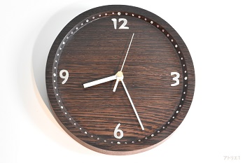 ウェンジの装飾的な木肌が堪能できるように丸い時計です。