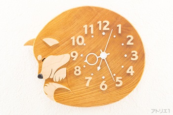 時計本体は、無垢のけやきで制作しました。けやきは、日本を代表する樹木で耐朽性、保存性がよく最良の材質の木で、お寺や大黒柱に好まれて使われる建築材としてだけでなく、和家具の最高級品としても重用されています。時刻の数字はメープルからひとつひとつ切り出しましたので、陰影で時刻が見やすくなっています。更にその内側にクリスタルのスワロフスキーを配しています。鼻は黒檀です。