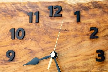 黒檀から一つ一つ切り出した時刻数字は、渦流のような杢をシックに引き立てます。