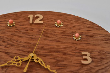12時・3時・6時・9時はブナの木を糸鋸で数字に切り、その他の時刻はピンクに染めた白サンゴを時刻目盛りにしました。サンゴは金色の座金にはめ、華やかな印象にしました。