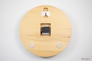 ムーブメントは、ステップ秒針の電波時計ですので、電池を入れるだけで正しい時刻を刻み始めます。ムーブメントのまわりに隙間があるのは、将来のムーブメント交換の際にどのようなものとでも交換できるようにとの配慮から大きめに加工しています。壁へのあたり部分は、壁を保護するようにフェルト仕上げになっています。