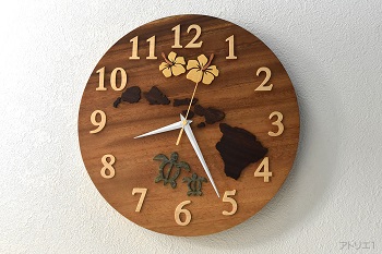 時計の真ん中ににハワイ諸島とハイビスカスの花を配したハワイの掛け時計です。時計のベースは、CMにある「この木なんの木、気になる木･･･」というテーマソングで映し出されるハワイ州のオワフ島にある「モアナルア・ガーデンパーク」にある木と同じモンキーポットです。