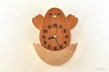 卵からかえったかわいいヒヨコの掛け時計です。ヒヨコはヒヨコらしい黄色が美しいけやきで作成。けやきは日本を代表する樹木で耐朽性、保存性がよく最良の材質の木で、お寺や大黒柱に好まれて使われる建築材としてだけでなく、和家具の最高級品としても重用されています。また、卵の部分は絹のような光沢がある白くて美しい栃を切り出しました。
