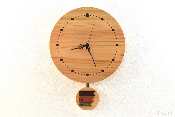 天然檜を直径30㎝の丸型に切り出した振り子時計です。振り子は、1ヶ月毎に交換できるように12か月分作成しました。