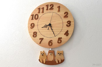 天然檜の丸い時計に愛犬のポメラニアン3頭が乗ったかごの振り子が付いた掛け時計です。