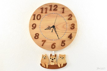 天然檜の丸い時計に愛犬のフレンチブルドッグとポメラニアンが乗ったかごの振り子が付いた掛け時計です。