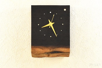 黒い色の木肌の高級木材ウエンジの辺材部分に現れた朝焼けのような希少な木目を生かし、スワロフスキーで明けの明星を配した時計です。