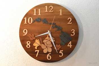 時計の真ん中ににハワイ諸島とプルメリアの花を配したハワイの掛け時計です。時計のベースは、CMにある「この木なんの木、気になる木･･･」というテーマソングで映し出されるハワイ州のオワフ島にある「モアナルア・ガーデンパーク」にある木と同じモンキーポットです。