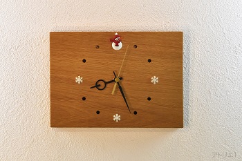 楢の長方形の無垢板にスノーマンと雪の結晶を配置したナチュラルでシンプルな掛け時計です。