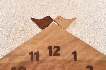 2羽の小鳥が仲良く向かい合って屋根の上にいるデザインです。時刻の数字はカリンの木をひとつずつ糸鋸で切り出しました。