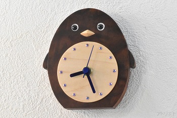 世界的な高級材であるブラックウオルナットの無垢材で作ったかわいいペンギンの掛け時計です。おなかの白い部分をハードメープルで時刻目盛りにして、くりっとした目と翼が変化したひれ状の「フリッパー」がチャーミングで、お部屋を楽しくします。