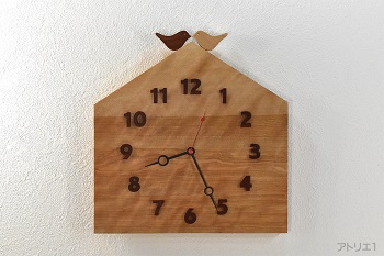 杢のある美しいカバザクラの木をおうちの形に切り出した掛け時計です。おうちの屋根に小鳥が乗っている幸せな形にデザインした可愛い時計に仕上げました。