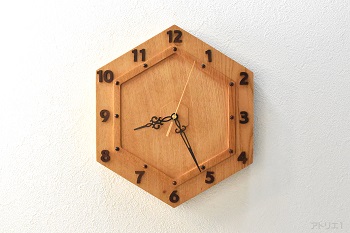 縁起の良い亀甲（きっこう）の形のインテリア掛け時計を日本を代表する樹木のけやきで制作しました。縁起のいい亀甲を全体の形だけでなく、時計の形の要素として幾重にも彫り込んで味わい深い造形にしました。