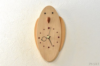 かわいいインコがあなたに話しかけてきそうな…そんなイメージで作ったブナの木の掛け時計です。羽は檜から切り出し、オニキスをまあるくつぶらな目に用いました。