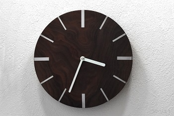 鏡に映すと正しく見える逆回転時計です。ベースのブラックウォルナットは装飾的な価値の高い波状の極めて珍しい木目の木材です。