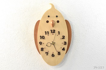 温かみのある白い木肌の銀杏をコンパクトに切り出し、オカメインコのチークパッチをマホガニーで表現してかわいい掛け時計にしました。時刻目盛りに数字を加えたので、時間もわかりやすくなっています。