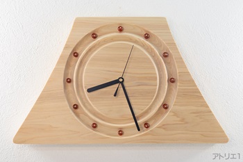 天然檜を富士山の形に切り出し、その内側を檜の木目が水紋のように表れるよう文字盤部分を丸く2重に彫り込みました。富士山の安定した形の「静」と波紋のように広がっていく「動」を併せて楽しめる掛け時計です。日本を印象的に感じられるデザインで、和室でも洋室でも楽しんでいただけると思います。