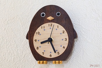 おなかの白い部分をハードメープルで時刻目盛りにして、くりっとした目と翼が変化したひれ状の「フリッパー」と黄色い足がキュートで、お部屋を楽しくするかわいいペンギンの掛け時計です。世界的な高級材であるブラックウオルナットの無垢材で作りました。