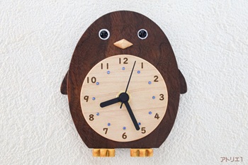 くちばしはハードメープル、目玉はオニキス、白目の部分はわずかに彫ってアクリル系塗料を塗ってあります。ペンギンの白いおなかの部分には時刻目盛りを柔らかい印象の数字をレーザーで刻印しました。更にその内側には南極の海をイメージして青色のスワロフスキーを配しました。足はブラジルの特にアマゾン川の下流域に分布しているイエローハートで作りました。