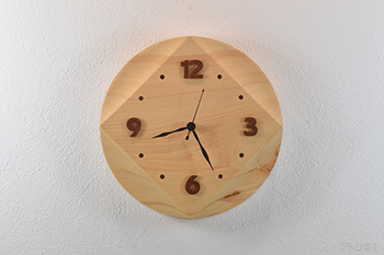 square the circle「円を四角にする」とは、「不可能な事をやろうとする（to attempt something impossible）」という意味ですが、この掛け時計は丸く切り出した檜の時計を光の当たり方によっては、四角い時計に見えるようにデザインしました。
