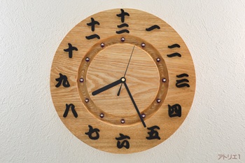 「和」の風情を新しい感覚で楽しめる漢数字を使った渋い無垢の木の掛け時計です。時計のベースには、広葉樹の中でも比較的硬く、その頑丈さから家具の材料として好まれているタモの無垢板を用い、時刻の数字に黒檀の漢数字を使用し、和を強く感じさせる時計にしました。