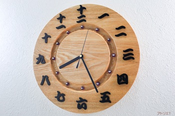 時刻の漢数字には、黒檀からひとつずつ切り出したものを使い、墨でしっかりと書き出されたように視認性をよくしました。時刻目盛りは紫水晶（むらさきすいしょう）ともいわれてる紫色のアメジストを使用しています。真鍮色の座金で止めて、和の高貴なイメージを感じるようにしました。