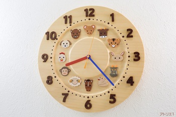 子供たちにもわかりやすい可愛い十二支がいる銀杏の掛け時計です。本格的な木の時計として永く使えるように銀杏の無垢板を使用しています。そんな銀杏の一枚板から丸く切り出し、その内側を少し彫り込んで十二支を配置し、その外側の周囲に時刻の数字を配しました。針は、小さなお子様にも説明しやすい赤、青、黄の３色としました。