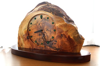 黒松の切り株を用い、木の皮もそのまま活かした置き時計です。黒松の松脂で固く締った木目で重厚なデザインに仕上がっています。