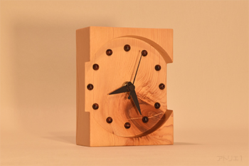 木曽檜の節のインパクトのある置き時計です。深く丸く彫り込んだ文字盤のデザインは、節をより立体的に深く見せ、両脇から時間が見やすいようにデザインしてあります。